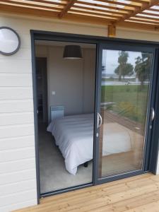 a room with a bed and a sliding glass door at Casa E Natura Lot 58 in Santa-Maria-Poggio