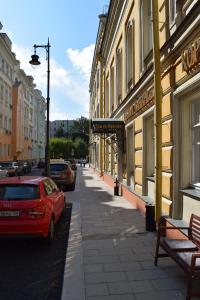 a street with a red car parked next to a building at Mayakovka House in Moscow