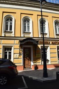 a yellow building with a car parked in front of it at Mayakovka House in Moscow