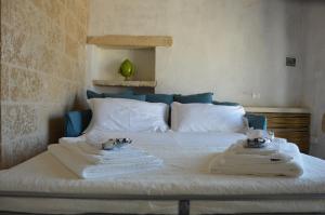 a bedroom with a bed with towels on it at Masseria Costa in Corigliano dʼOtranto