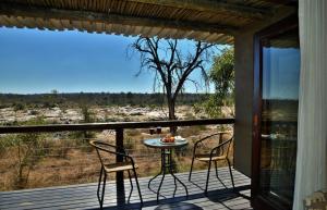 um pátio com 2 cadeiras e uma mesa no deque em Mjejane River Lodge em Hectorspruit