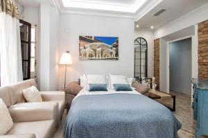 ein Schlafzimmer mit einem großen Bett und einem Sofa in der Unterkunft ECO CENTER GRANATENSIS free parking in Granada
