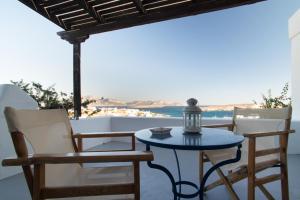 a table and chairs on a patio with a view of the ocean at Alkionides Studios in Koufonisia