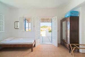 a bedroom with a bed and an open door at Alkionides Studios in Koufonisia