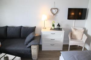 een woonkamer met een bank en een dressoir bij Seaside Appartement 458 Vier Jahreszeiten in Hahnenklee-Bockswiese