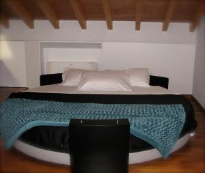 a bed with a green blanket on top of it at Parizzi Suites & Restaurant in Parma