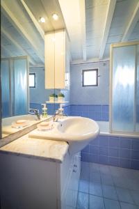 baño con lavabo blanco y azulejos azules en Oltrarno Apartment, en Florencia