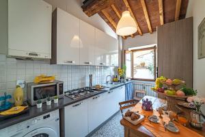 Una cocina con gabinetes blancos y una mesa en ella. en Oltrarno Apartment, en Florencia 24 fotos más