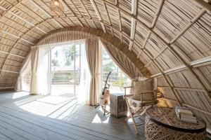 a room with a guitar and a chair in a room at Jaiyen Boutique Resort in Ko Yao Noi