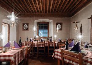 una sala da pranzo con tavoli, sedie e luci di Langley Hotel La Vieille Ferme a La Salle-les-Alpes