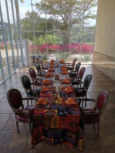 a long table with chairs in a room with flowers at Jambo Mara Safari Lodge in Ololaimutiek