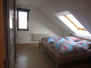 a bedroom with a bed and two skylights at Ferienwohnung Küpfer in Gräfenberg