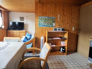 a room with a table and a kitchen with wooden walls at Haus Burgblick in Obertrubach