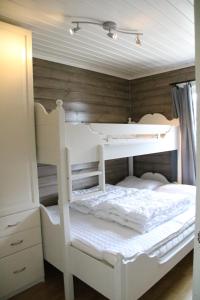 a white bunk bed in a room with wooden walls at Myrkdalen Resort Nedre Byggardslii apartment in Vossestrand