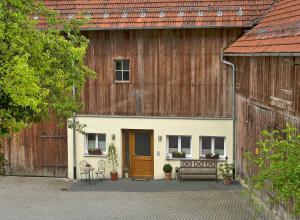 un granero con una puerta y un banco delante de ella en Landurlaub Wittmann, en Pegnitz