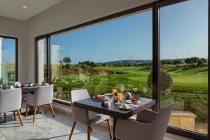 ein Esszimmer mit Blick auf einen Golfplatz in der Unterkunft Aphrodite Hills Rentals - Junior Villas in Kouklia