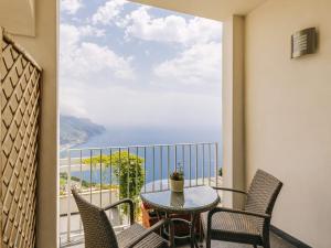 balcón con mesa, sillas y vistas al océano en Hotel Villa Fraulo, en Ravello