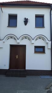 Biały dom z brązowymi drzwiami w obiekcie Vinný sklípek Na Spojovací w mieście Mutěnice