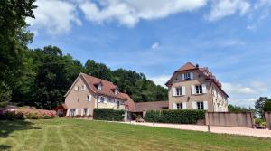 ein großes Haus und ein Haus mit Hof in der Unterkunft Maison d'Hôtes Les Jardins de Madeleine in Bernardvillé