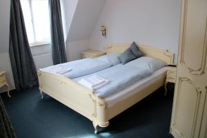 a white bed with blue sheets in a room at Zum neuen Schwan in Walluf