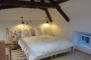 ein Schlafzimmer mit einem weißen Bett mit Vögeln an der Wand in der Unterkunft La Layotte in Vosne-Romanée
