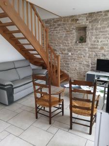 ein Wohnzimmer mit einer Treppe, Stühlen und einem Sofa in der Unterkunft La Layotte in Vosne-Romanée