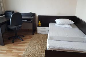 a bedroom with a bed and a desk and a chair at Apartament Gia in Oradea