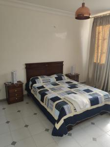Schlafzimmer mit einem Bett mit einer blauen und weißen Bettdecke in der Unterkunft Appartement hyper centre de Tanger (Boulevard Pasteur) in Tangier