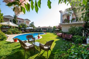 a backyard with a pool and chairs and a table at Mercan Köşk in Alaçatı