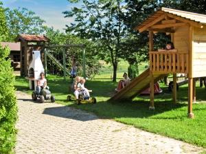 - un groupe d'enfants à bord d'une voiture jouets dans une aire de jeux dans l'établissement Fürstnerhof Chiemsee, à Rimsting