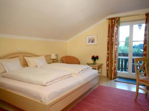 Un dormitorio con una gran cama blanca y una ventana en Fürstnerhof Chiemsee en Rimsting