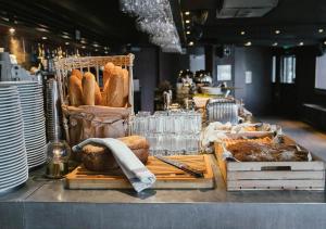 un mostrador de panadería con pan, platos y vasos en Langley Hôtel Victors en Val dʼIsère