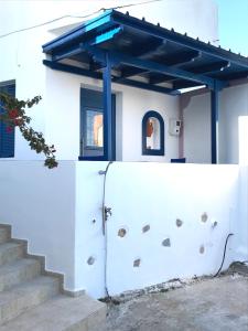een witte muur met een blauw dak op een huis bij Asimina Studios in Donoussa
