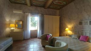 a bedroom with a bed and a chair and a window at Le Ginestre in San Gimignano