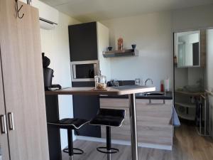 een keuken met een aanrecht en krukken in een kamer bij Loft "Plus belle la vue" in Vinezac