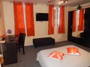 La Roche-ChalaisにあるChez Corinneのベッドルーム1室(オレンジ色のカーテン、ベッド1台、テーブル付)