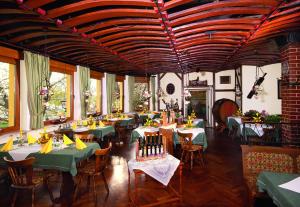 uma sala de jantar com mesas e cadeiras verdes em Hotel-Restaurant Zur Mainlust em Maintal