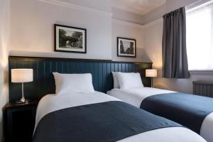 ワトフォードにあるSouthern Crossのベッド2台と窓が備わるホテルルームです。