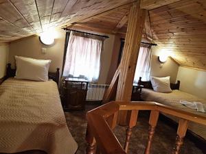 een slaapkamer met 2 bedden en een houten plafond bij Hotel St. George Pobedonosets in Bansko