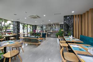 um restaurante com mesas e cadeiras de madeira e um bar em Meliora Hotel & Apartment em Da Nang