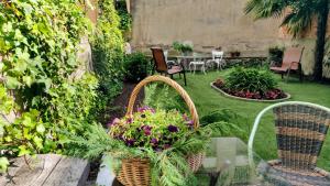 a garden with baskets of flowers and a table and chairs at El Jardinet de Sant Esteve in Olot