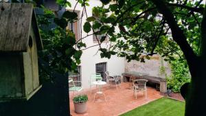un patio con sillas, una mesa y un banco en El Jardinet de Sant Esteve, en Olot