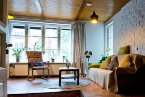 a living room with a couch and a chair at Spacious Klaipeda Apartment EV in Klaipėda