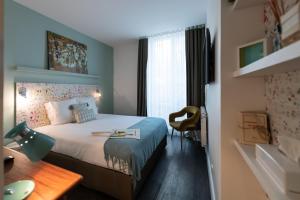 a hotel room with a bed and a desk and a room at 1er Etage Marais in Paris