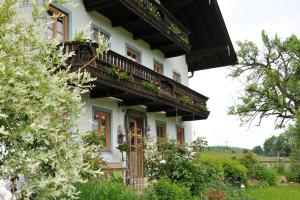 a white house with balconies and flowers on it at Hochgallinger Hof in Siegsdorf