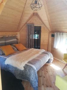 a bedroom with a bed in a wooden cabin at Camping Loisirs Des Groux in Mousseaux-sur-Seine