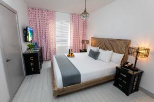 
a bedroom with a bed and a dresser at Whitelaw Hotel in Miami Beach
