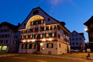 un bâtiment avec des lumières sur le côté d'une rue dans l'établissement Hotel Bären, à Rothenburg