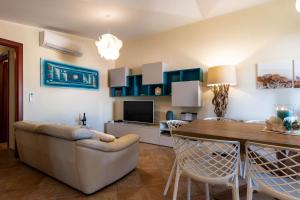 un soggiorno con divano e sala da pranzo di La Casa delle Conchiglie a Villasimius Altre 15 foto