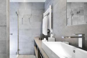 uma casa de banho com um lavatório e um chuveiro em La Ferme du Château em Lucens